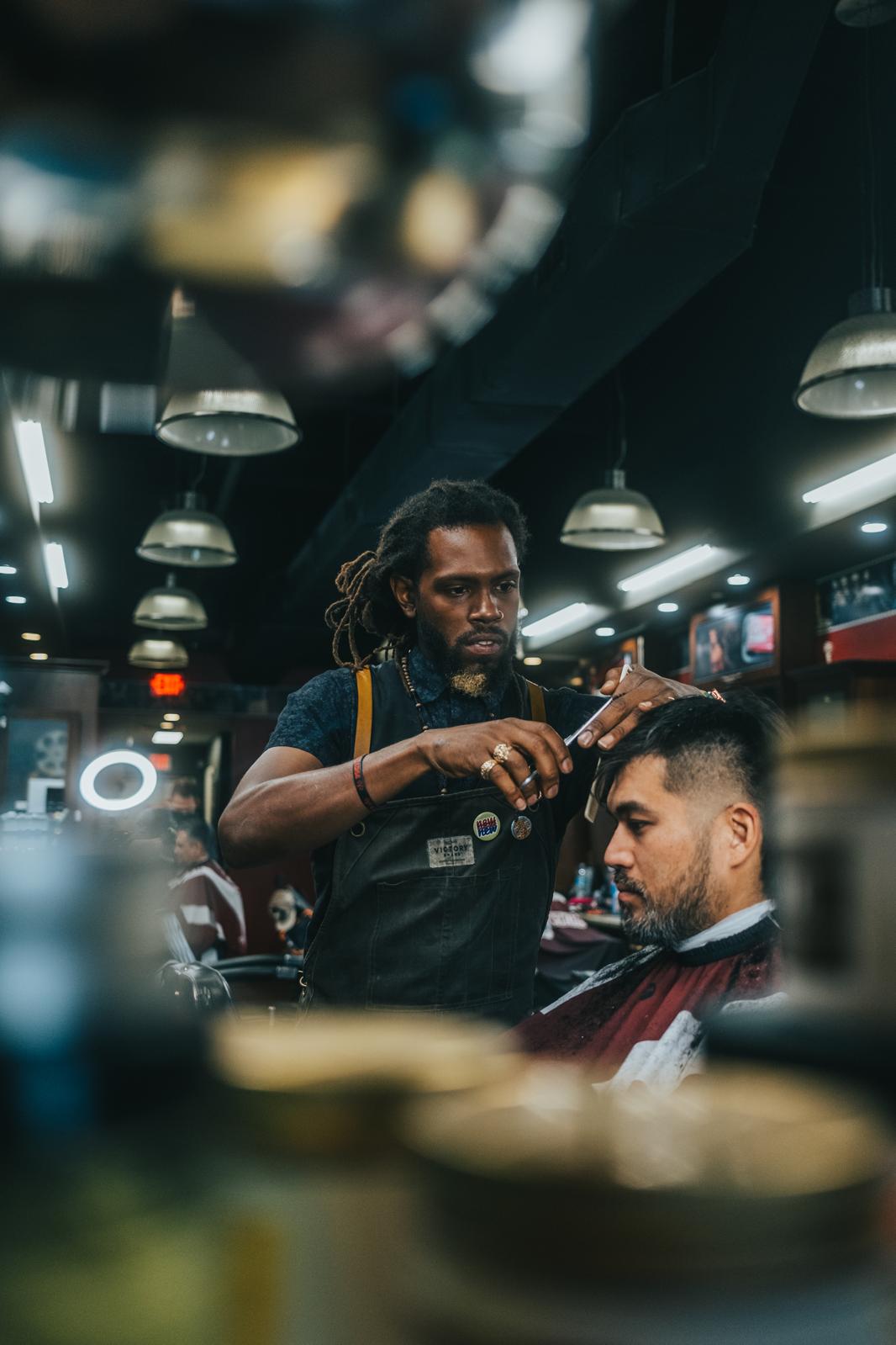 Professional barber with dreadlocks providing expert service in the shop